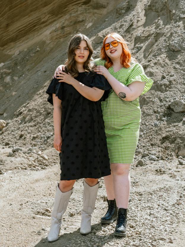 Two women wearing black and green sustainable Aarrelabel dresses