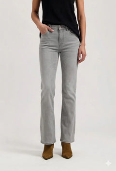 Person wearing light gray jeans and brown boots on a white background