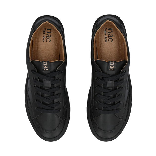 Black sneakers with brown insole on a white background