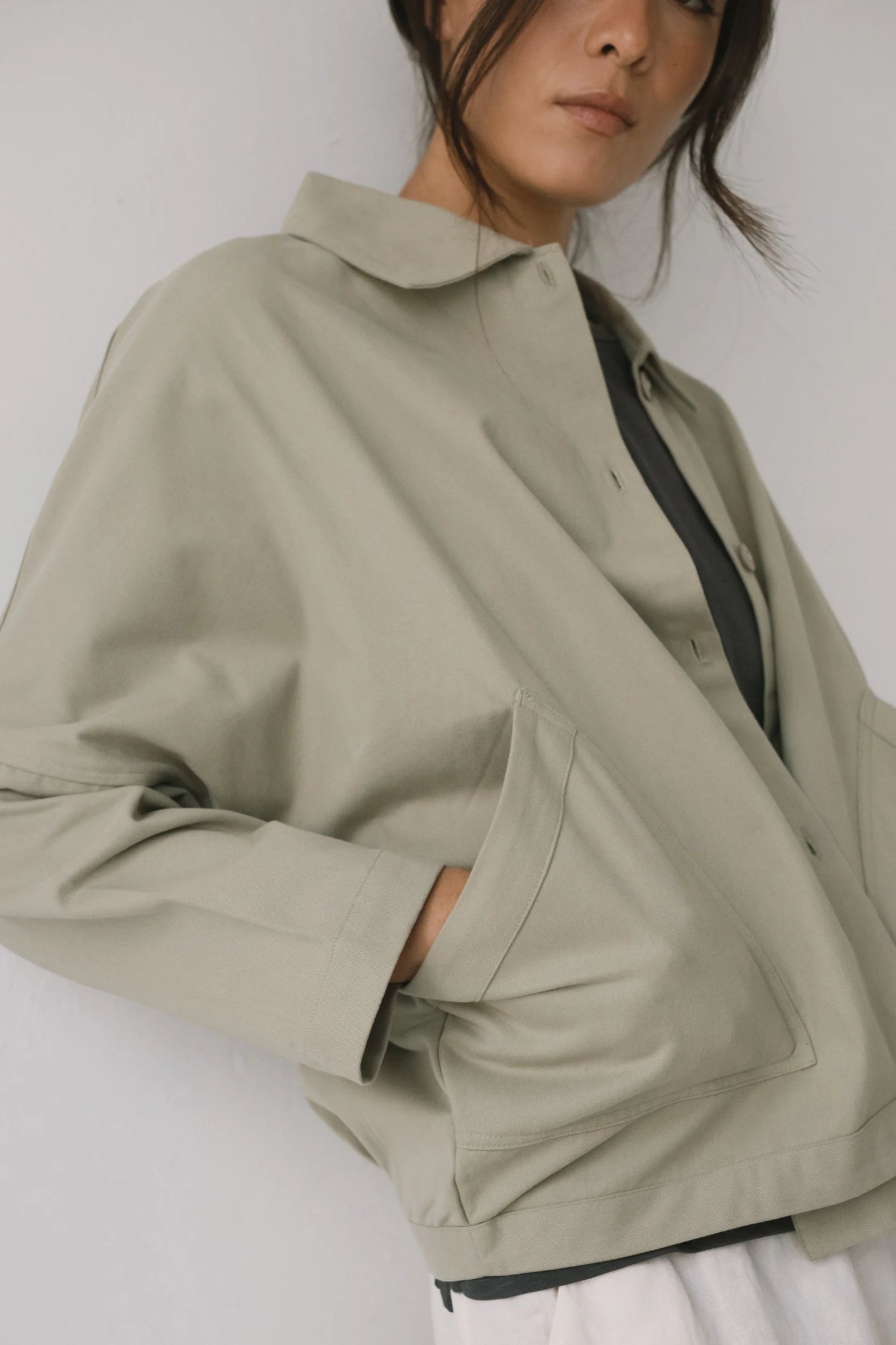 Person wearing a beige jacket on a plain background