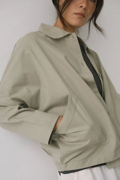 Person wearing a beige jacket on a plain background