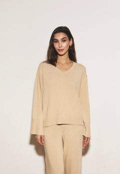 Woman wearing a beige outfit against a white background