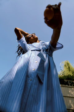 Woman in a blue dress against a clear blue sky