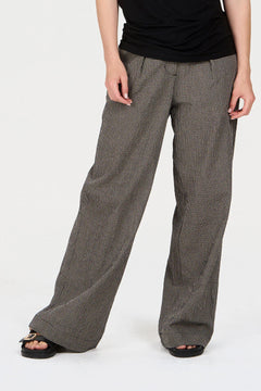 Person wearing wide-leg checkered pants on a white background