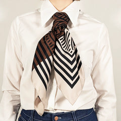 Person wearing a patterned scarf on a plain background