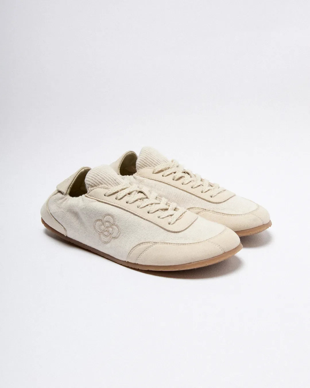 Pair of beige sneakers on a white background