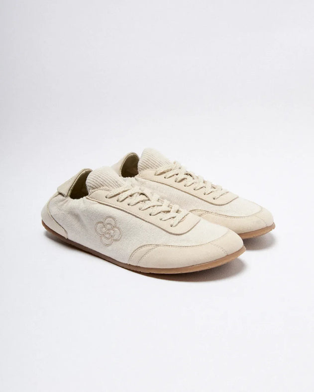 Pair of beige sneakers on a white background
