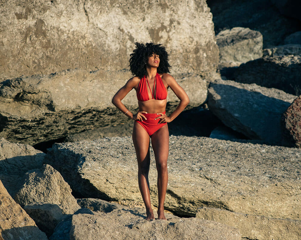 Woman in a red bikini standing on rocky terrain