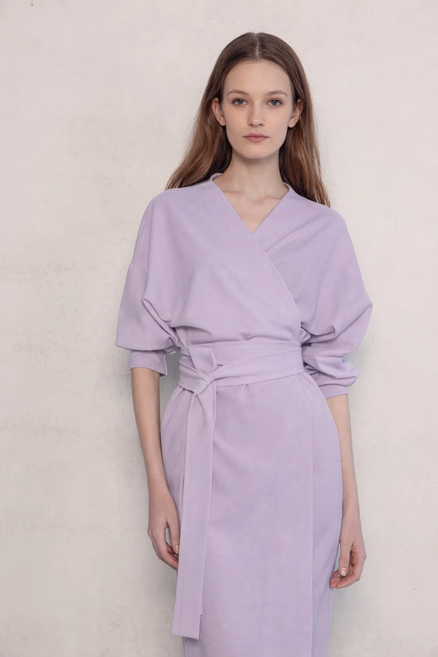 Woman wearing a light purple dress against a plain background