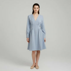 Woman wearing a light blue dress on a plain background