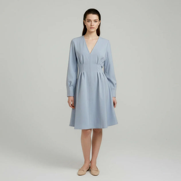Woman wearing a light blue dress on a plain background