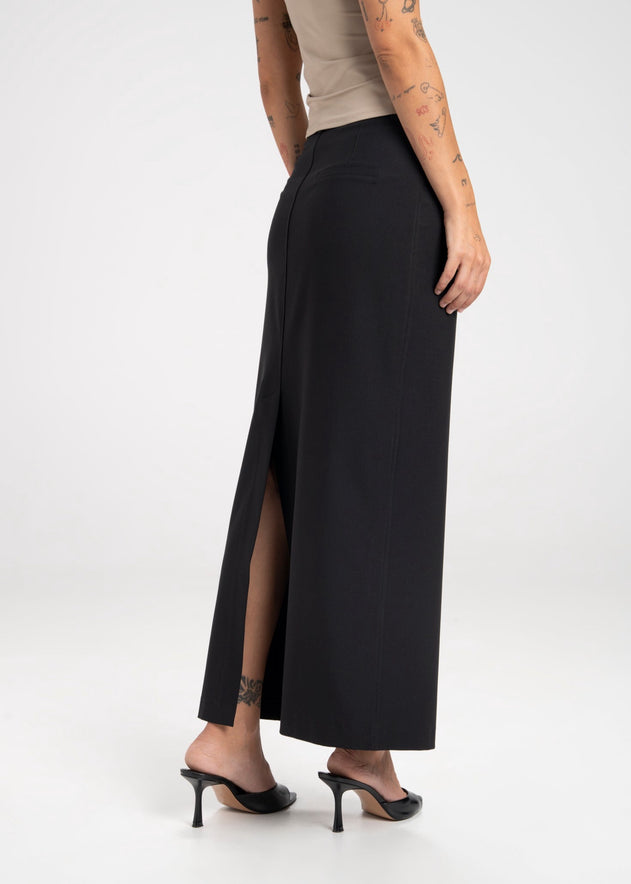 Black skirt with a high slit worn by a person on a white background