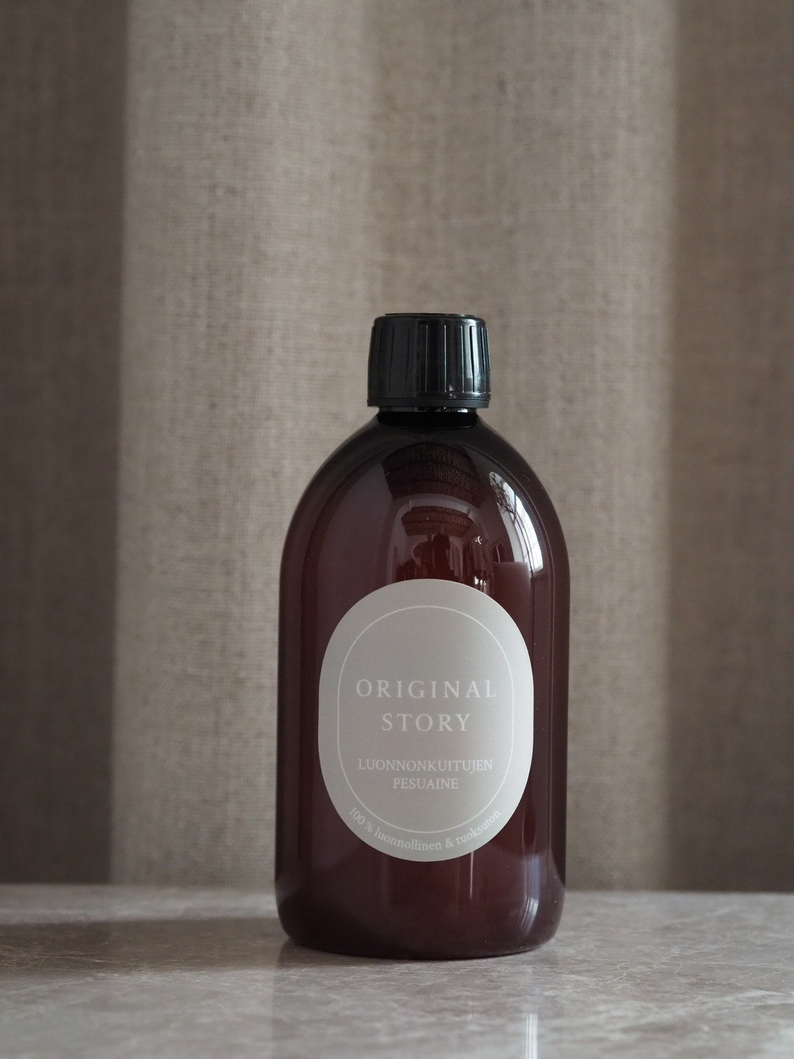 Brown bottle with a black cap on a neutral background