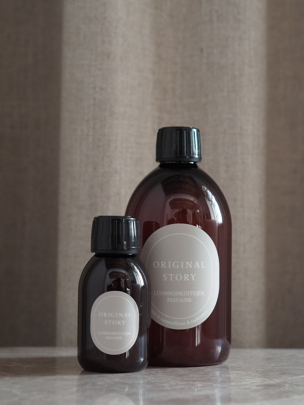 Two bottles with labels on a neutral background