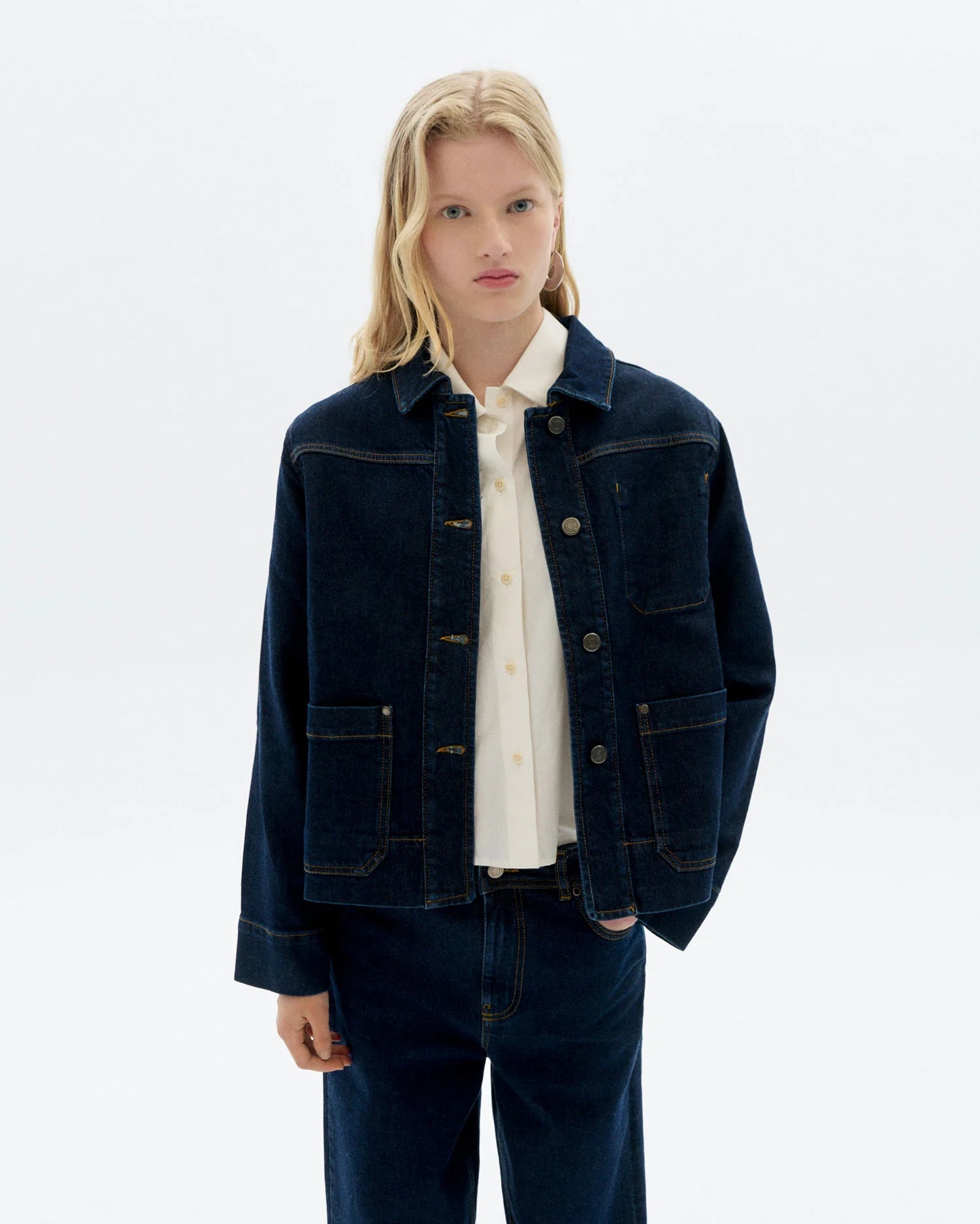 Person wearing a dark blue jacket over a white shirt on a light gray background